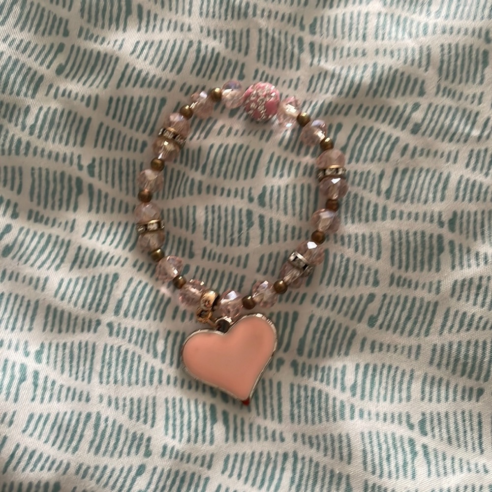 A pink bracelet with a pink heart